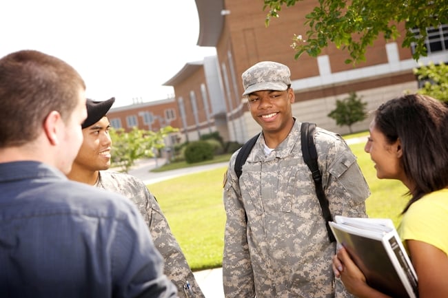 Students in military uniforms talk with civilian students