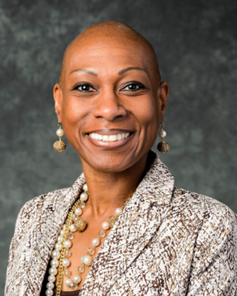 A professional headshot of Antoinette “Bonnie” Candia-Bailey, a Black woman, who smiles widely.
