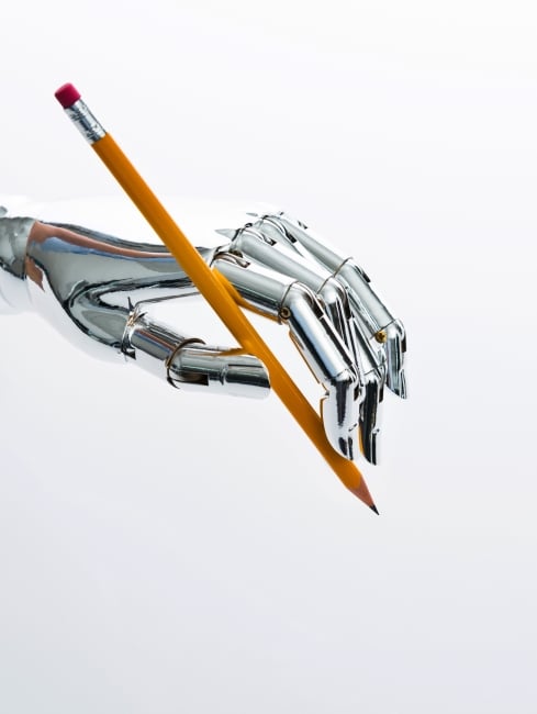 Robot hand holds pencil facing down as if about ready to draw