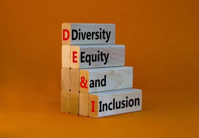 A stack of four wooden blocks with the words "Diversity, Equity and Inclusion" against an orange background.