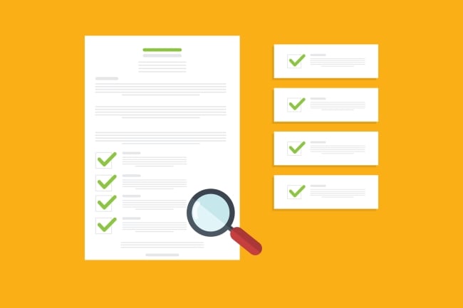 Magnifying glass on top of a paper with approval checkmarks; paper is beside smaller pieces of paper, each with a checkmark, as well