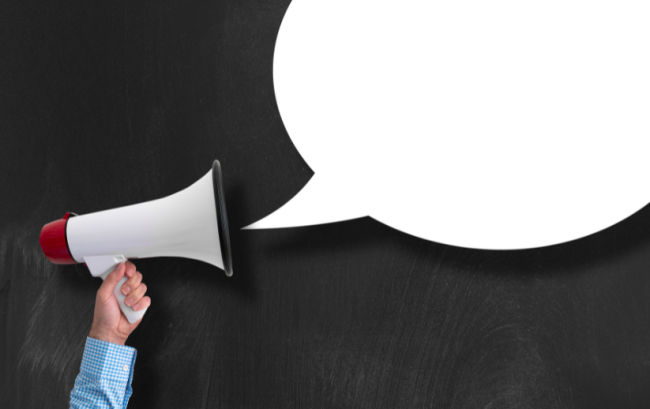 A graphic of a hand holding up a bullhorn emitting an empty white speech bubble, against a black background.