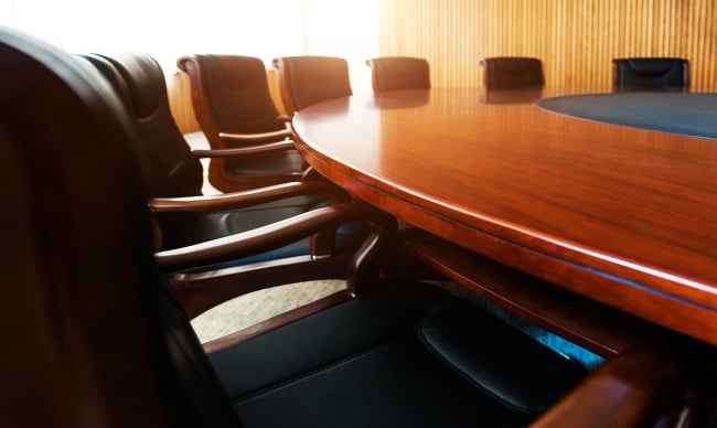 A photo of chairs around a sleek conference table.