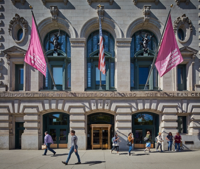 Students walk in front of a stone building that has School of the Art Institute of Chicago emblazoned across the front