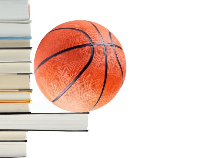 Basketball perches on book protruding horizontally from a stack of books