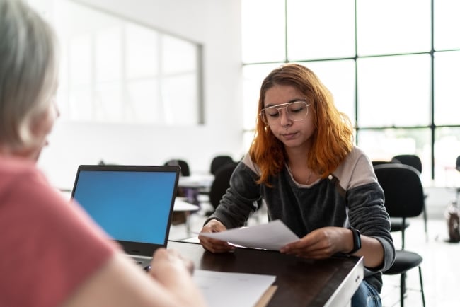 Woman helping a female student with a paper