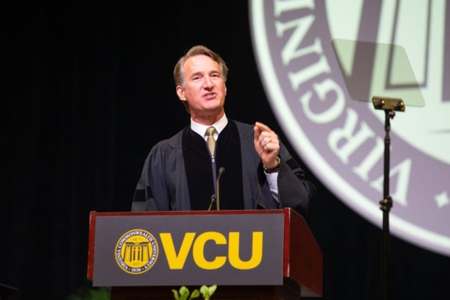 A photograph of Virginia governor Glenn Youngkin speaking behind a lectern bearing Virginia Commonwealth University’s logo and the letters “VCU.”