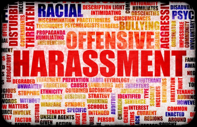 A word cloud featuring words associated with harassment. The word “harassment” is largest and in the center. Other prominently featured words (among dozens) include “offensive,” “racial,” “bullying,” “aggressive,” and “threatening.”