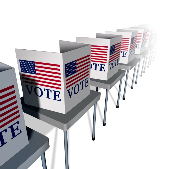 An illustration of a row of empty voting booths, each with an American flag and the word "VOTE," lined up on tables.