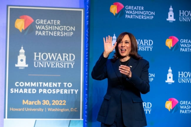 Kamala Harris waving in front of a sign at Howard University
