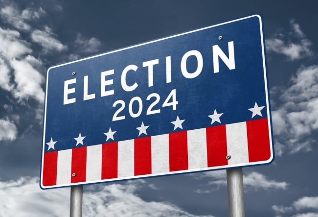 A red, white and blue highway billboard sign that says "Election 2024" above stars and stripes.