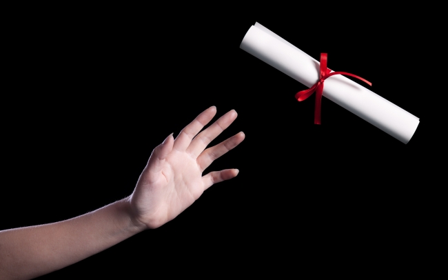 A hand reaching for a diploma