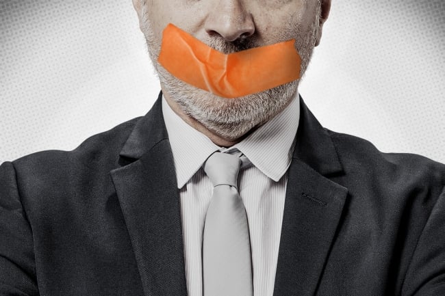 A photo illustration of a man in a blazer and tie with tape over his mouth.