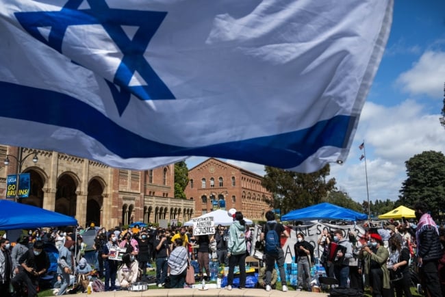 UCLA Jewish students waving Israeli flags counterprotest fellow students in their Palestinian solidarity camp on their Westwood campus on Thursday, April 25, 2024. College protests around the country are seeking their schools divest from Israel over the Israel-Hamas war.