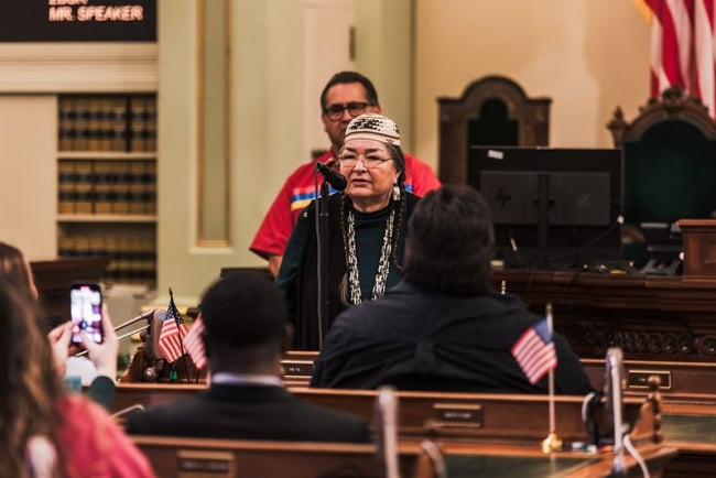 Annette Reed, dean of Sacramento State's new Native American College, speaks into a microphone.