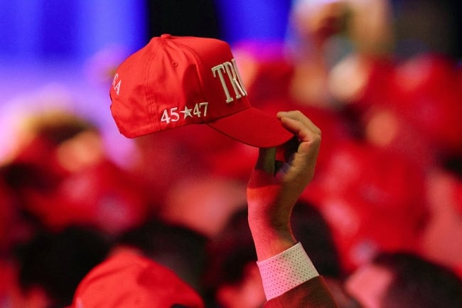 A photo of a supporter holding a Trump hat.