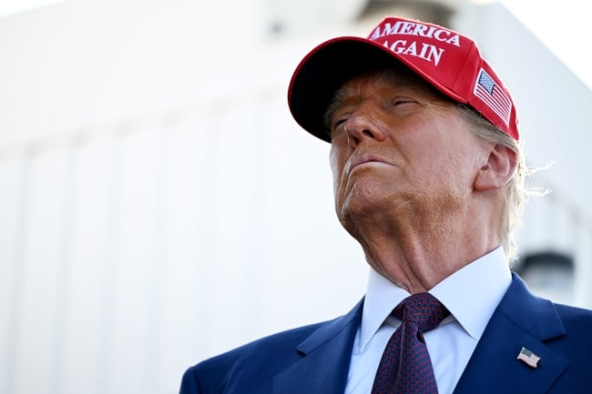 President Trump wears a red hat and a suit and tie
