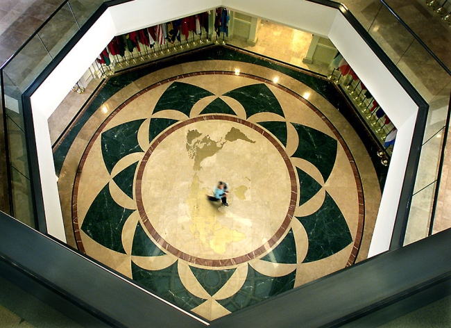 A worker crosses the world map embedded in the floor of the rotunda area inside Founders Hall on the campus of Soka University of America.