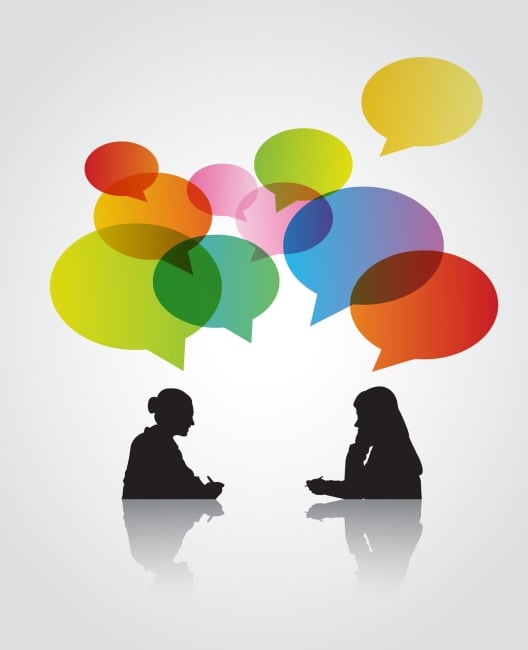 An illustration of two women, in silhouette, talking, with multicolored speech bubbles above their heads.