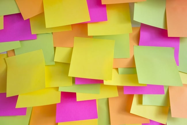 Layers of multicolored sticky notes completely cover the surface underneath.