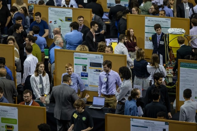 Students present papers and are surrounded by spectators