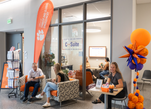 Students smile and chat outside the Clemson University C-Suite career development hub