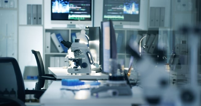 A photo of an empty biomedical laboratory with a microscope and other equipment.