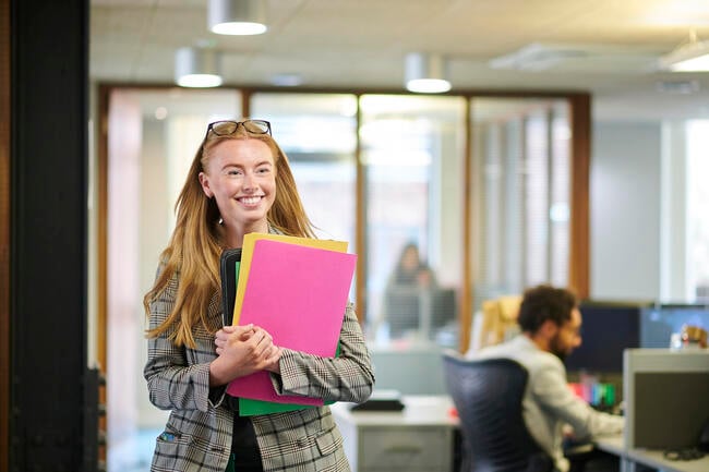 Happy young paralegal walking through the office