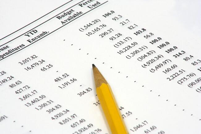A photo of a budget spreadsheet with a pencil lying on top.