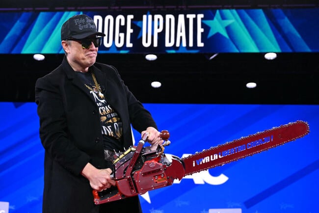 Elon Musk plays with a chain saw on stage at the Conservative Political Action Conference in February. He is wearing sunglasses indoors.