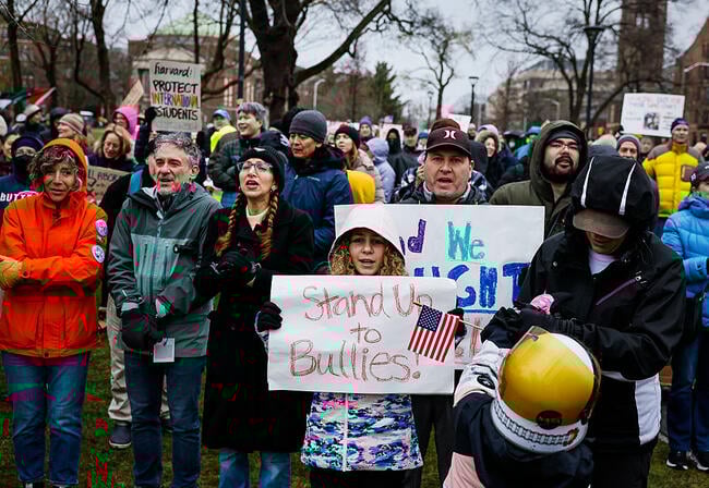 Protesters hold signs including "Harvard: Protect International Students" and "Stand Up to Bullies!" during a Cambridge Common rally.