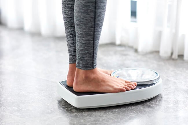 Young girl on home scale