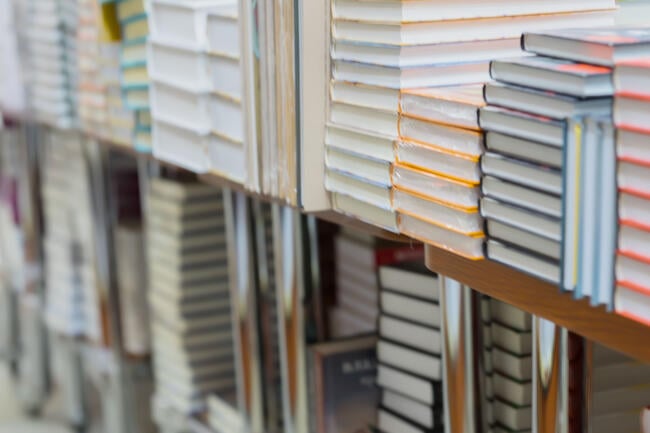 Stacks of books, textbooks or fiction in bookstore or in library
