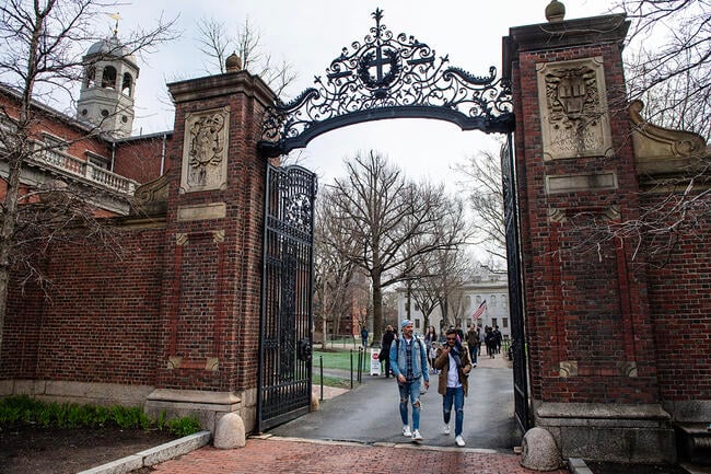 People walk through a gate as they exit Harvard Yard on the campus of Harvard University.