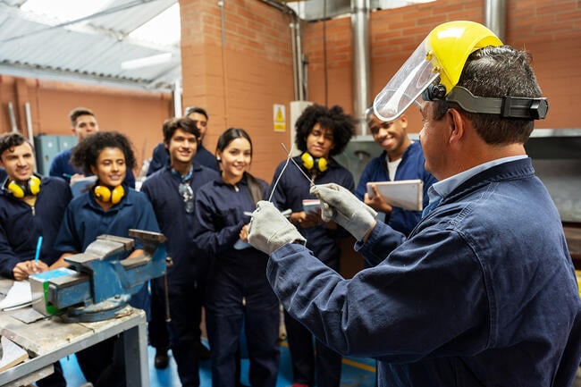 Group of college students in an engineering class looking at the instructor and paying attention.