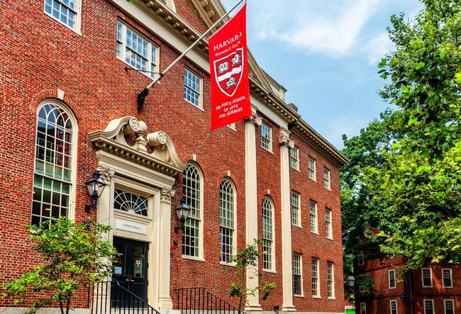 A flag with the Harvard University logo hangs above the entrance of Harvard's Lehman Hall.