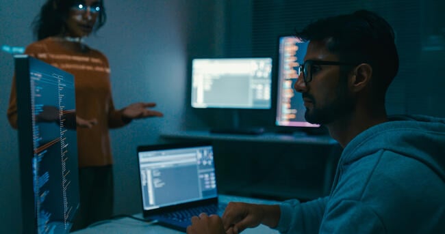 Female programmer is giving an interactive training session, focusing on hands-on learning in digital classroom environment. Software developer, artificial intelligence and programming concept.
