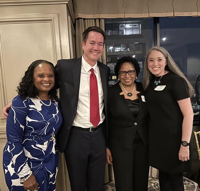 Four people in a photo, three women and one man