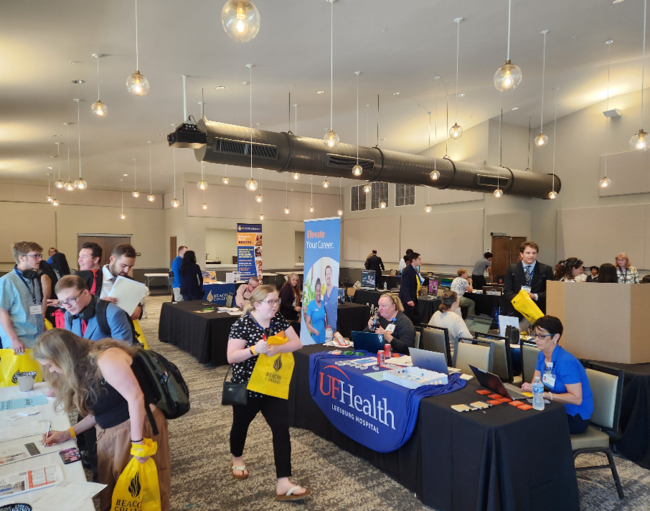 Students walk through a career fair in a conference center space