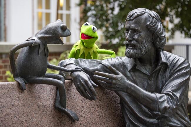 Kermit the puppet smiles at a bronze likeness of himself and Jim Henson at the University of Maryland, College Park, campus
