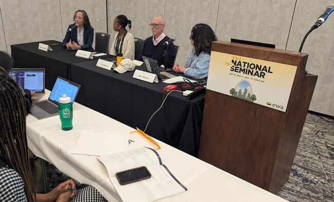 Four panelists sit at a table next to a lectern with the Education Writers Association logo on it.