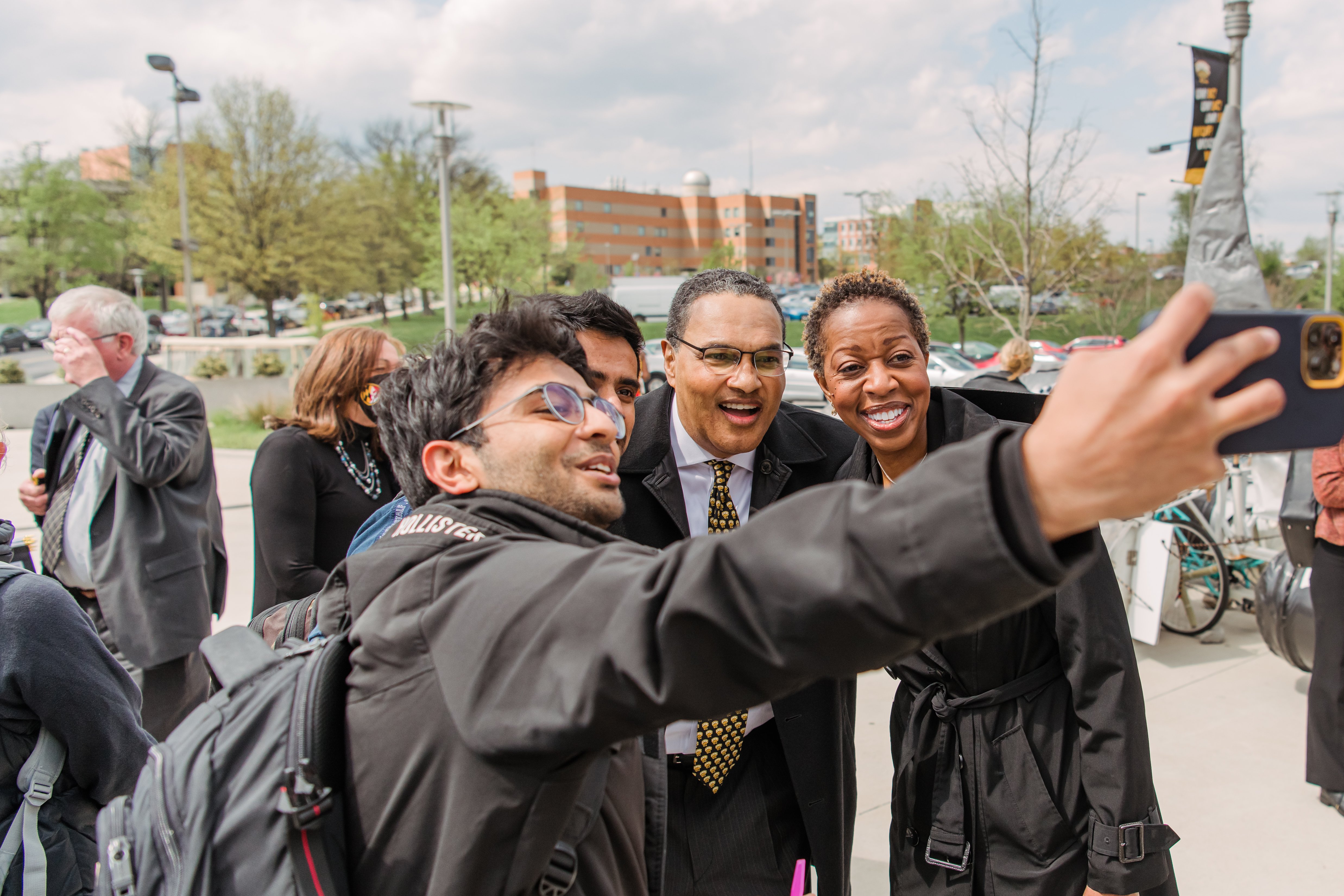 Freeman Hrabowski and Valerie Sheares Ashby, a Black woman with short hair, take a photo with two students.