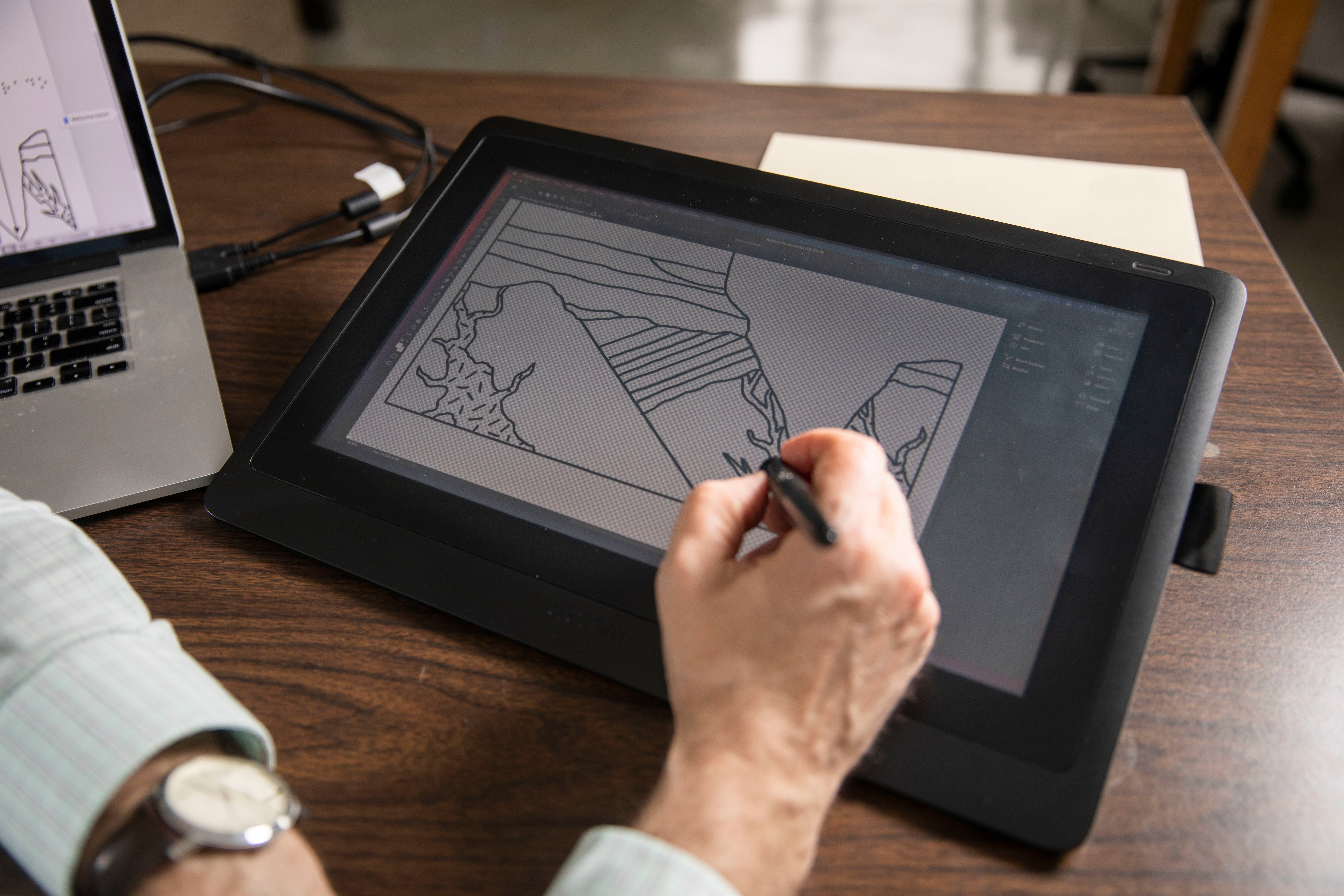 Image: Kent Ratajeski drawing the template for a textile graphic on a tablet.