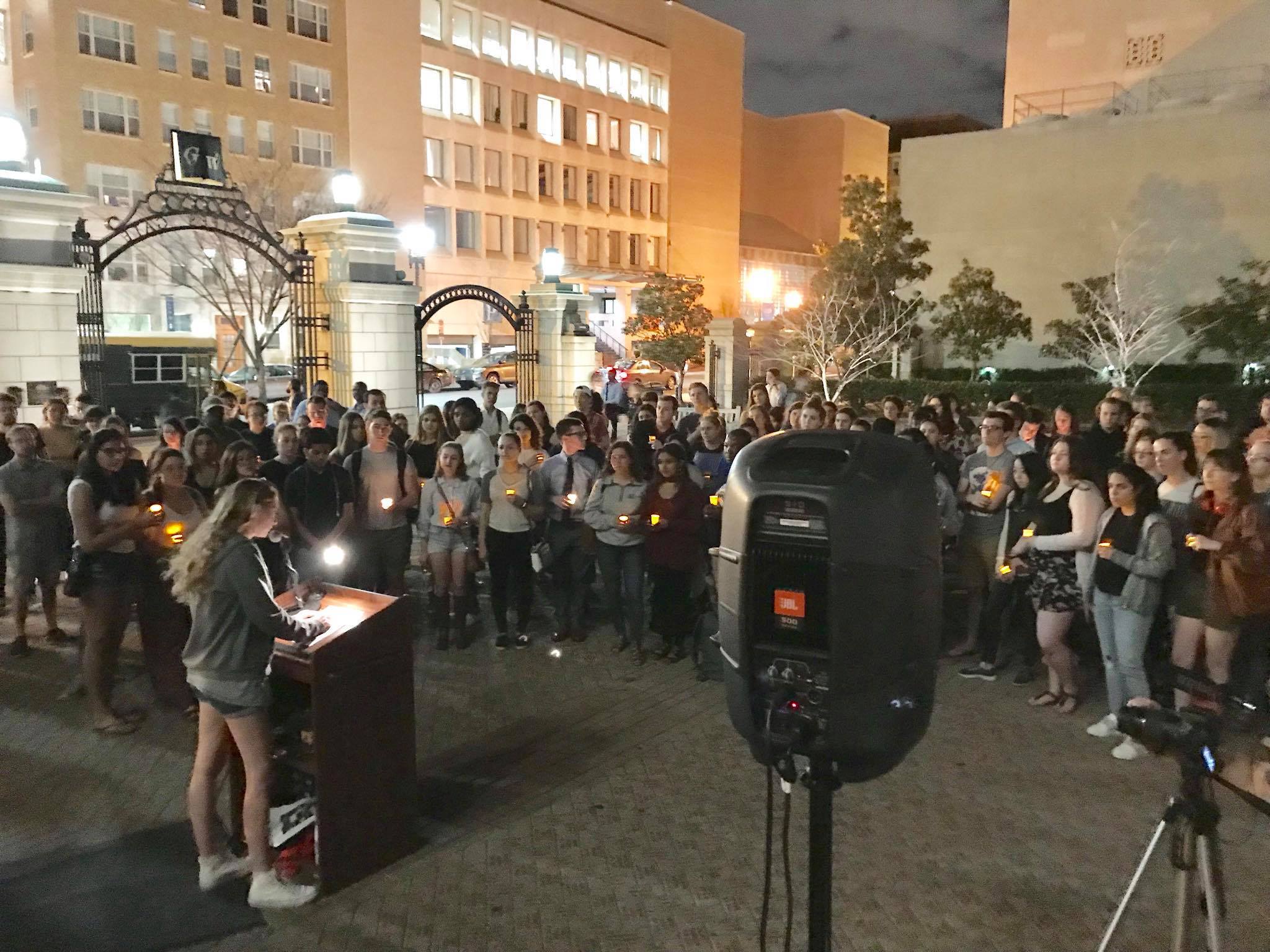 Photo shows George Washington students at a candlelight vigil for shooting victims.