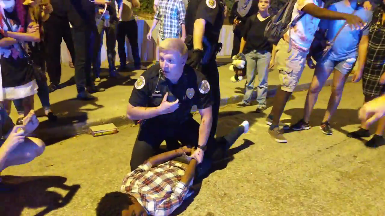 A Georgia Tech police officer handcuffs a protester, who is lying facedown on the ground, at a protest after the shooting death of Scout Schultz.