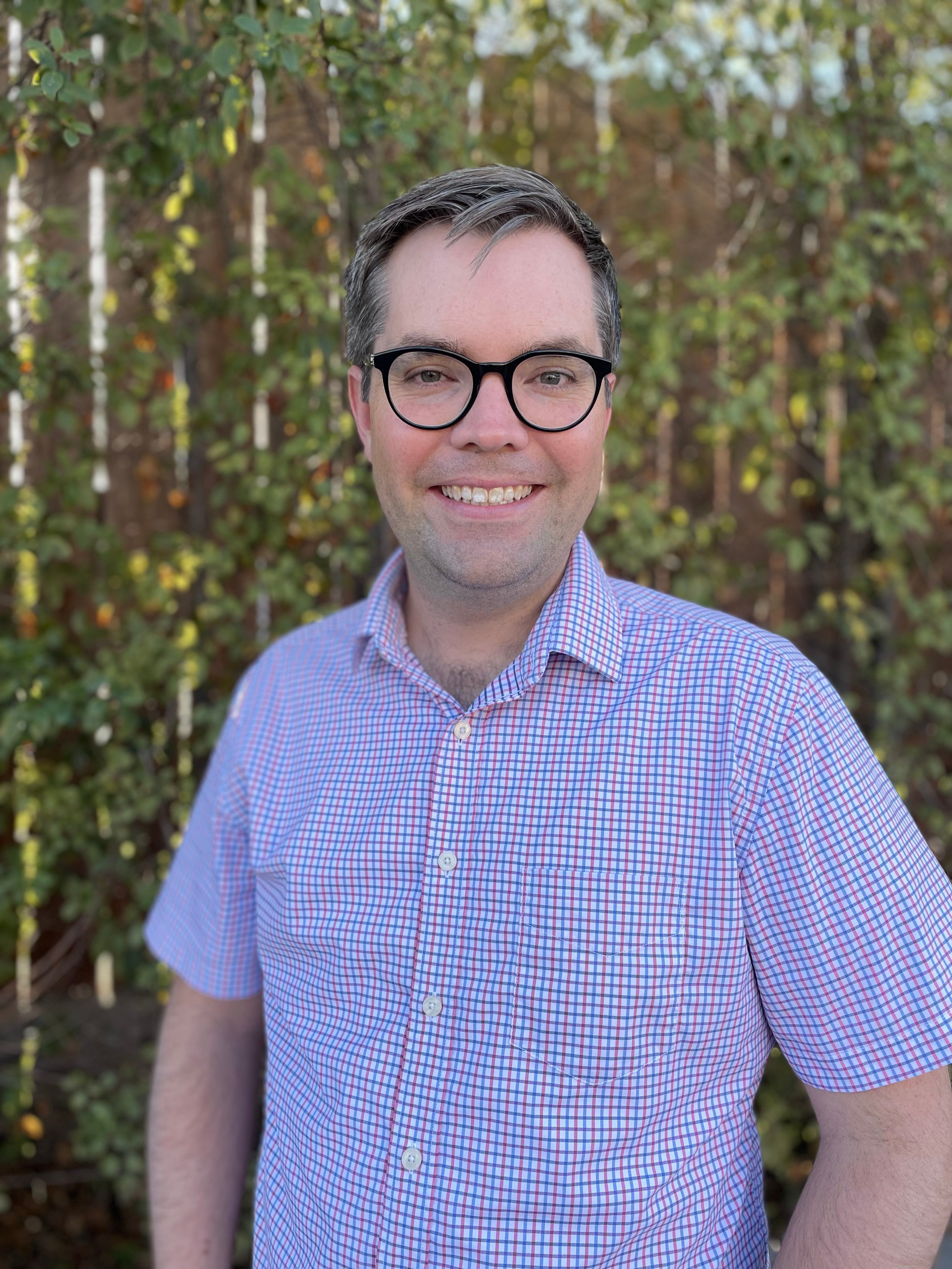 Andy Specht, a white man with glasses wearing a button-down shirt.