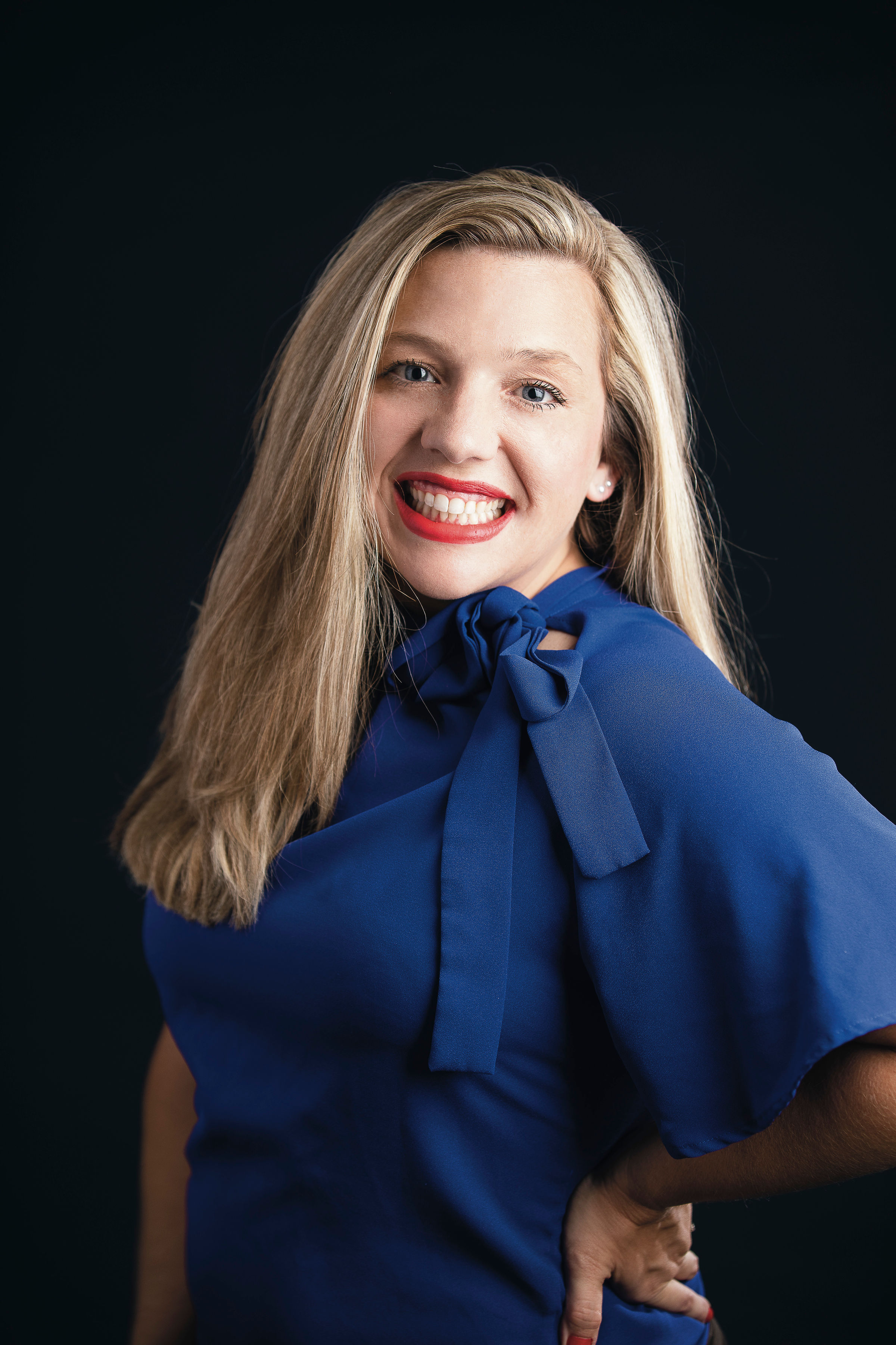 Lindsey Keith-Vincent, a white woman with blond hair wearing a blue blouse with a bow at the neck.