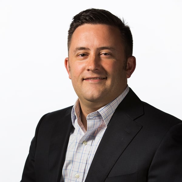 James DeVaney, a white man with dark hair wearing an open-collared shirt and blazer.