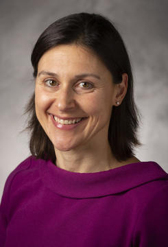Jenny Frederick, a white woman with dark hair wearing a magenta top.