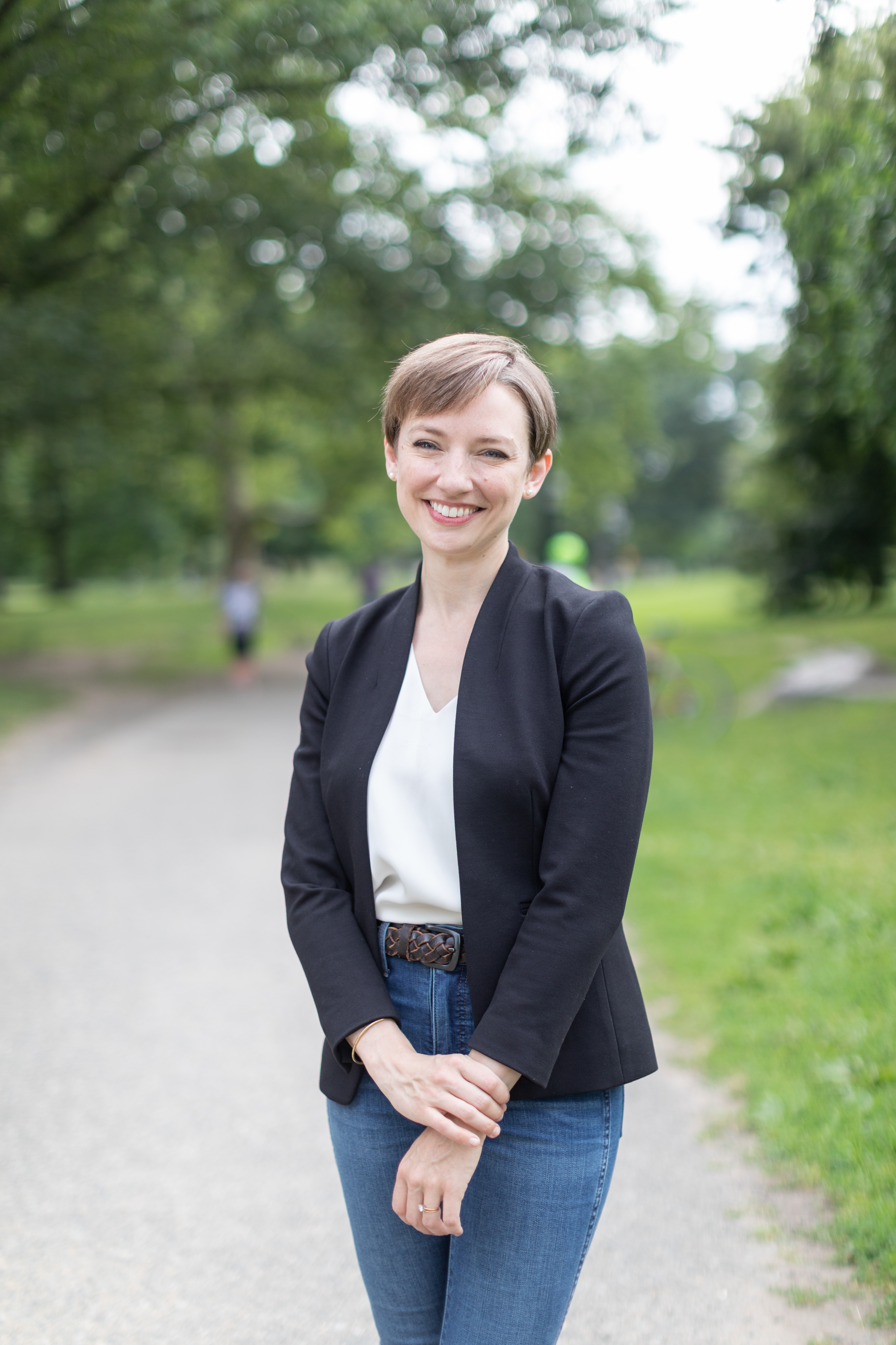 Kelly Heuer, a light-skinned young woman with short brown hair wearing a blazer.